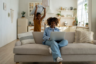 Portrait of woman sitting on sofa at home