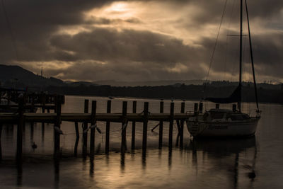 Boats moored in marina at sunset