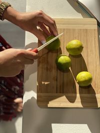 Cropped hands of man cutting board