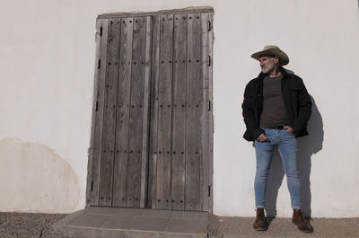 Portrait of adult man in cowboy hat and jeans against wall. almeria, spain