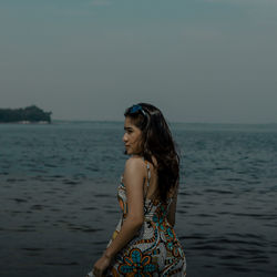 Woman looking at sea against sky