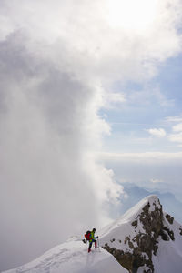 People on snowcapped mountain against sky