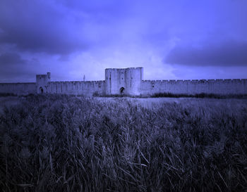 Built structure on field against sky