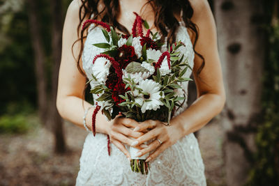 Midsection of woman holding white flower