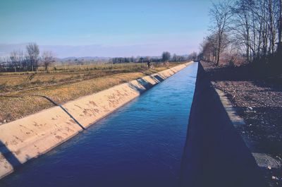 Road by river against sky