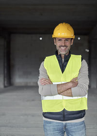 Portrait of young man standing against wall