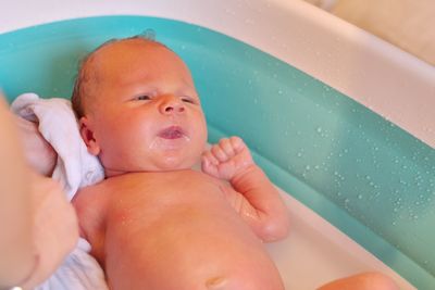 Newborn baby being bathed by his mother