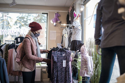 Woman with face mask shopping clothes