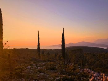 Built structure on landscape against sky during sunset