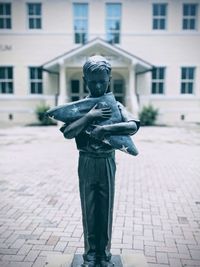 Statue of man standing on footpath