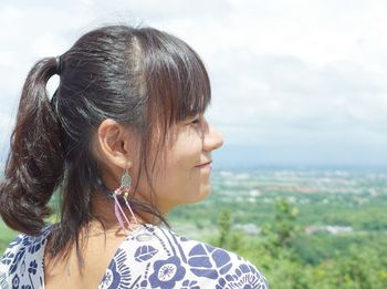 Rear view of young woman looking away against sky