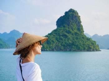 Woman looking at sea against mountain