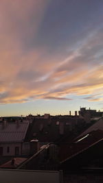 Houses in town against sky during sunset