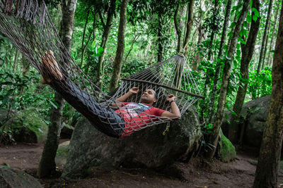 Man relaxing on hammock in forest