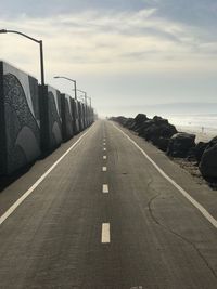Road by sea against sky