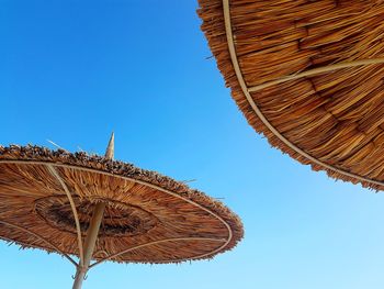 Low angle view of traditional windmill against clear blue sky