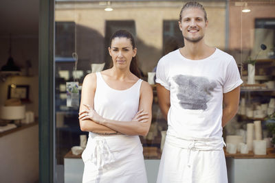 Portrait of smiling workers standing outside crockery workshop