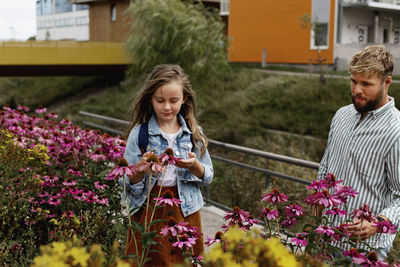 Happy girl with flowers against plants