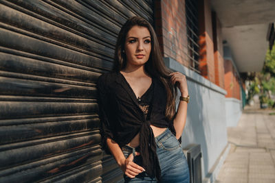 Portrait of beautiful young woman standing with umbrella