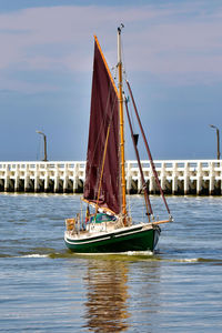 Sailboat sailing on sea against sky