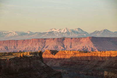 Last light on canyon walls in utah desert with la sal mountains behind