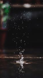 Close-up of drop falling on water