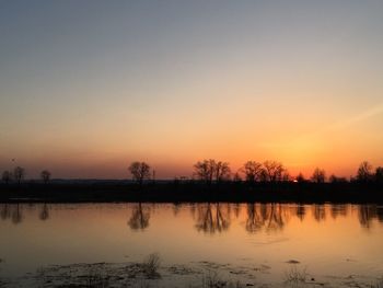 Scenic view of lake against romantic sky at sunset