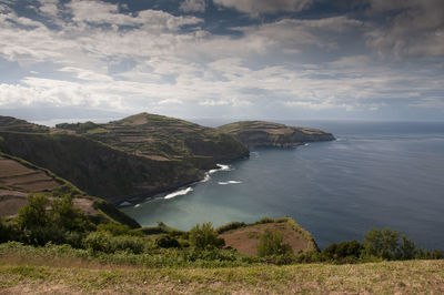 Scenic view of sea and mountains against sky