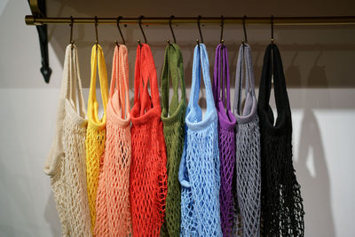 Colorful eco-friendly shopping string bags on hangers, multicolor mesh woven eco-bags