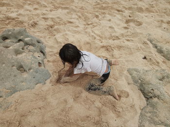 High angle view of woman on rock at beach