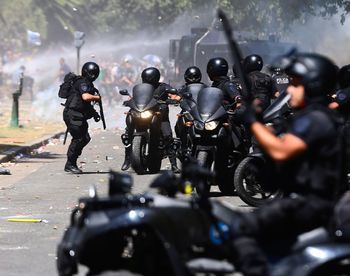 Close-up of security guards with motorcycle on road