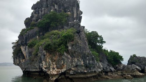 Rock formations by sea against sky