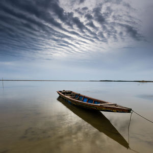 Boat moored on sea against sky