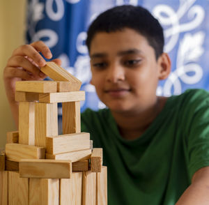 Close-up portrait of a boy playing with wooden blocks