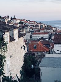 High angle view of townscape by sea against sky