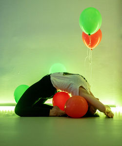 Close-up of multi colored balloons on table against wall