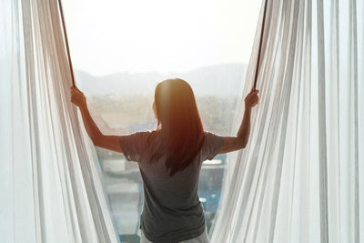 Low section of woman standing by window