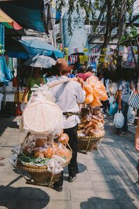 Vendor with carrying pole at street market