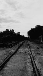 Railway tracks on landscape against sky