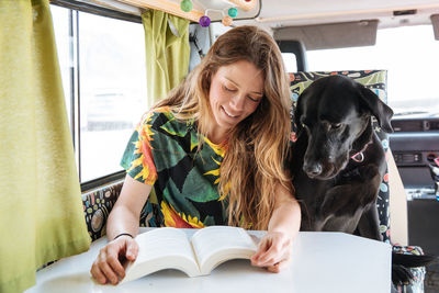 Woman traveling with dog in camper van