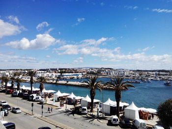 View of cityscape by sea against sky