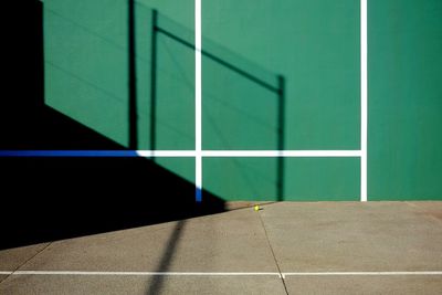Shadow on green wall at tennis court