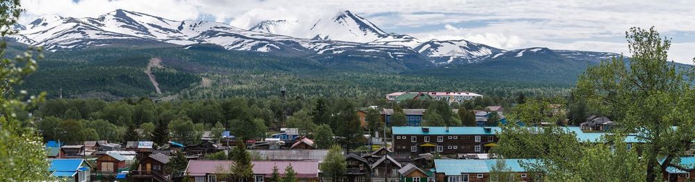 Panoramic view of trees and houses against sky