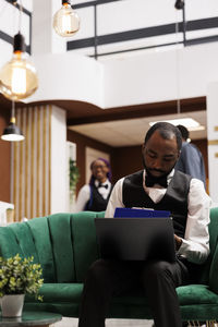 Portrait of young man using laptop while sitting in cafe