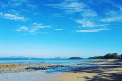 Scenic view of beach against blue sky