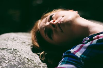 Close-up of young woman lying on grass