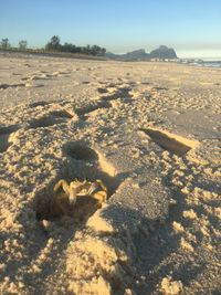 Shadow on sand at beach against sky