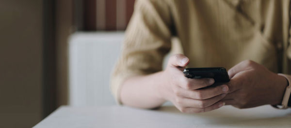 Midsection of man using mobile phone