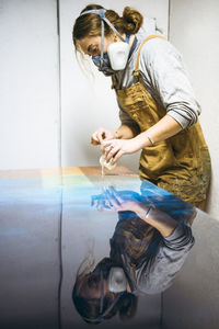 Female resin artist using simple materials to perfect artwork