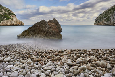 Scenic view of rocks in sea against sky